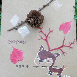나뭇잎과 나무가지, 솔방울 등으로 한지 위에 사슴을 표현한 이미지
